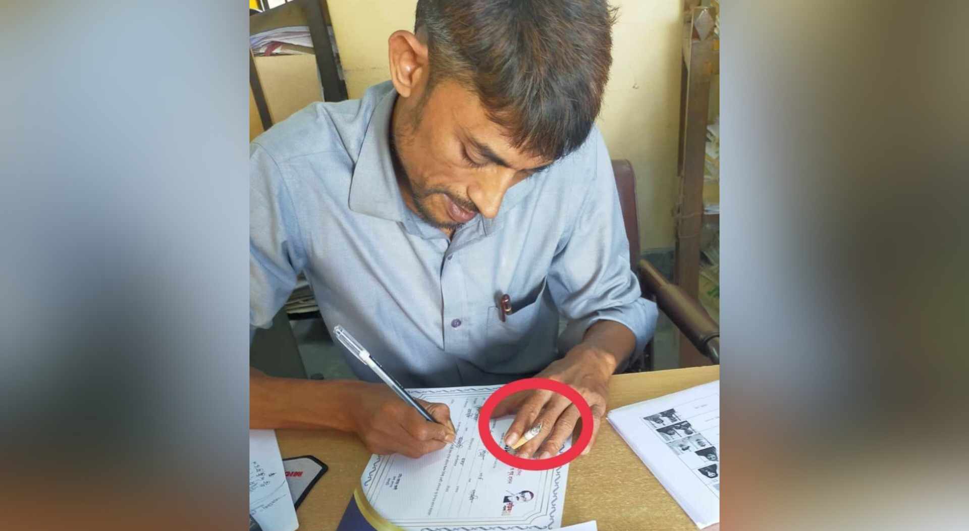 মুজিব বর্ষের লোগো নিচে রেখে সিগারেট টানেন উপ সহকারী প্রকৌশলী